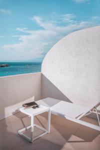a white chair sitting on top of a sandy beach at Hotel Moresco in Santa Teresa Gallura