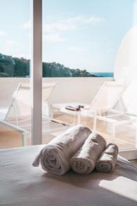 a group of towels sitting on a bed in a room at Hotel Moresco in Santa Teresa Gallura