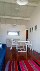 ein Wohnzimmer mit einem weißen Tisch und Stühlen in der Unterkunft Encantador departamento frente al mar 4 Amb in Villa Gesell