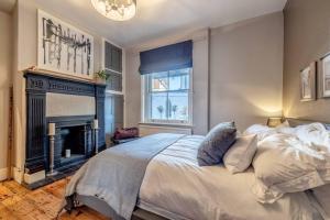 a bedroom with a large bed and a fireplace at COUPLES RETREAT - THE LONG WALK, WINDSOR CASTLE in Windsor