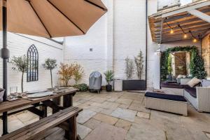 an outdoor patio with a table and an umbrella at COUPLES RETREAT - THE LONG WALK, WINDSOR CASTLE in Windsor