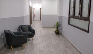 a hallway with two chairs and a plant at Hostal Tartessos in Valencia
