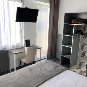 a bedroom with a desk and a chair next to a bed at L'Auberg'ine - Maison Glenn Anna in Sainte Anne d'Auray