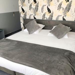 uma grande cama branca com duas almofadas em L'Auberg'ine - Maison Glenn Anna em Sainte Anne d'Auray