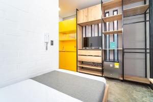 um pequeno quarto com uma cama e um armário amarelo em Ayenda Living Box em Cali