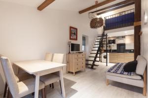 ein Wohnzimmer mit einem Tisch und Stühlen sowie eine Küche in der Unterkunft Appartement avec terrasse in Marseille
