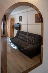 - un canapé noir dans le salon avec un miroir dans l'établissement Penzion U Hejtmana, à Klatovy