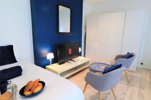 un salon avec une table blanche et un mur bleu dans l'établissement Studio SAINT-VINCENT 150M DU PORT, à Vannes