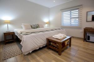 1 dormitorio con 1 cama grande y 1 mesa en Waggi Mountain Escape, en Addo