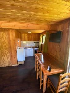 a kitchen and dining room with a table in a cabin at Cabañas-apartamentos Borde Río in Neltume