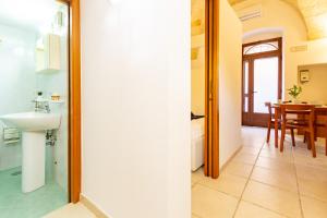 a bathroom with a sink and a table in a room at Appartamento Rosa Blu PT - MyHo Casa in Torre Canne