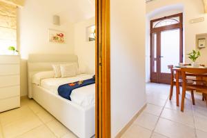 a bedroom with a bed and a mirror at Appartamento Rosa Blu PT - MyHo Casa in Torre Canne
