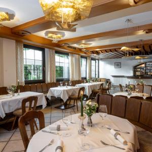 a restaurant with white tables and chairs and windows at Gasthof Feichter in Finkenstein