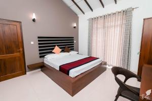 a bedroom with a bed and a table and chairs at Monaara Leisure - NuwaraEliya in Nuwara Eliya