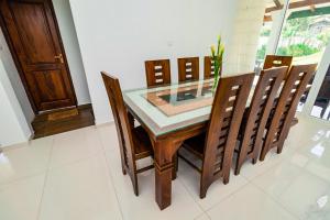a dining room with a glass table and chairs at Monaara Leisure - NuwaraEliya in Nuwara Eliya