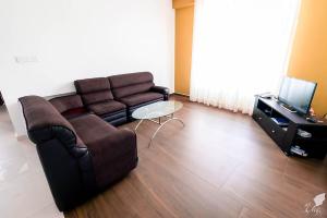 a living room with a couch and a table at Monaara Leisure - NuwaraEliya in Nuwara Eliya