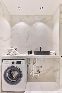 a white laundry room with a washing machine and a sink at 96 - Urban Musée du Louvre in Paris