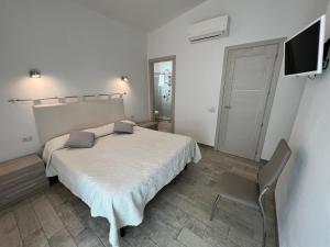 a bedroom with a bed and a tv and a chair at in campagna da Nino in Olbia
