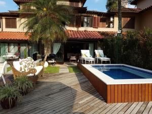 a backyard with a swimming pool and a house at Casa no Condomínio Porto Frade - pertinho da praia in Angra dos Reis