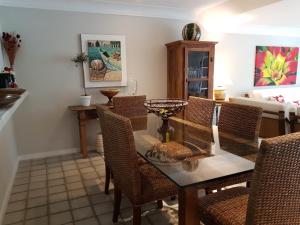 a dining room with a table and wicker chairs at Casa no Condomínio Porto Frade - pertinho da praia in Angra dos Reis
