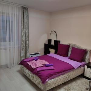 a bedroom with a large purple bed with purple pillows at Гостиница Суворов in Kobryn