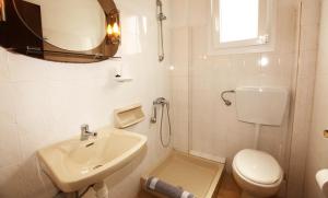 a bathroom with a sink and a toilet and a mirror at Haus Sofis in Koinyra +66 photos