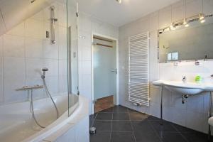 a bathroom with a tub and a sink and a shower at Ostseetraum Wohnung OG in Wittenbeck +7 photos