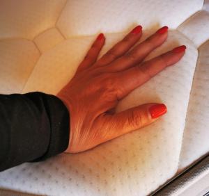 una mano con esmalte de uñas rojo está en una mesa en Ey Lisbon GuestHouse, en Lisboa