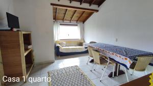 a living room with a table and a couch at Casa em Ilhabela SP in Ilhabela