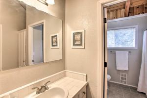a bathroom with a sink and a mirror at Lakefront Retreat with Hot Tub about 7 Mi to Schweitzer! in Sagle