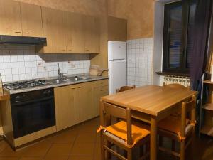 a kitchen with a table and a sink and a refrigerator at Lago e Monti in Colico