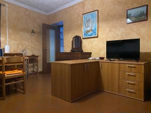 a living room with a television on a wooden cabinet at Lago e Monti in Colico
