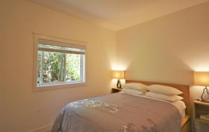 a bedroom with a bed with two pillows and a window at Pender Harbour Resort & Marina in Garden Bay