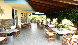 a restaurant with wooden tables and chairs and a patio at Haus Sofis in Koinyra