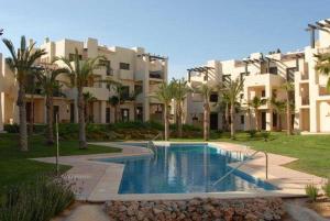 una piscina frente a un gran edificio en Roda Golf Resort FIT FOX, en Murcia