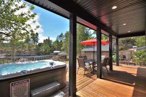 a deck with a hot tub and a table with chairs at Pender Harbour Resort & Marina in Garden Bay