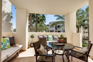 een patio met een tafel en stoelen en een bank bij Roda Golf Resort FIT FOX in Murcia