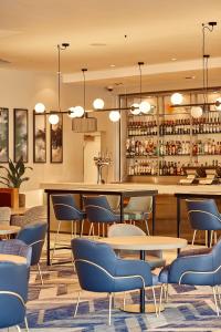 a restaurant with a bar with blue chairs and tables at Crowne Plaza Reading East in Reading