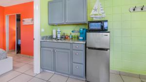 a kitchen with a refrigerator and a microwave at The Beach House - Treasure Island in St. Pete Beach