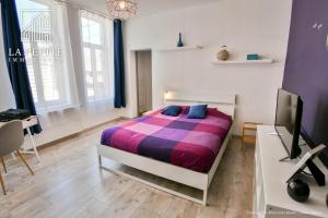 a bedroom with a bed and a desk and a tv at Villa des Ursulines in Valenciennes