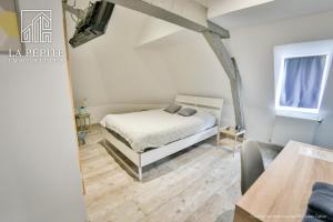 a bedroom with a bed and a wooden floor at Villa des Ursulines in Valenciennes