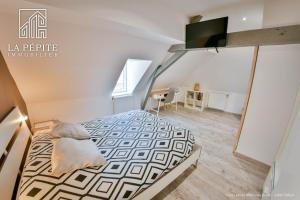 1 dormitorio con 1 cama y TV. en Villa des Ursulines, en Valenciennes