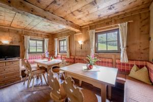 a dining room with two tables and a tv at Landhaus im Grünen in Sölden