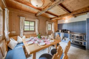 eine Küche und ein Esszimmer mit einem Holztisch und Stühlen in der Unterkunft Landhaus im Grünen in Sölden