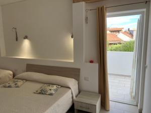 a bedroom with two beds and a large window at Al Mare da Francesca in Olbia