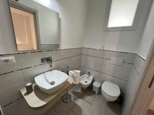 a bathroom with a sink and a toilet and a mirror at Al Mare da Francesca in Olbia