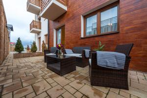 a patio with chairs and a table on a brick wall at Apartments Mons in Vila Katalina in Zlatibor