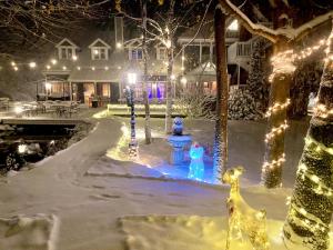 un cortile decorato con luci di Natale nella neve di The Cornell Inn a Lenox