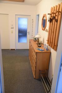 a room with a wooden dresser and a door at Gästehaus Steffen in Upgant-Schott