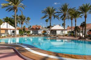una grande piscina in un resort con palme di Tropical Lodge a Maspalomas